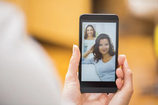 Gros plan d'une main féminine tenant un smartphone pendant un skype vid — Photo