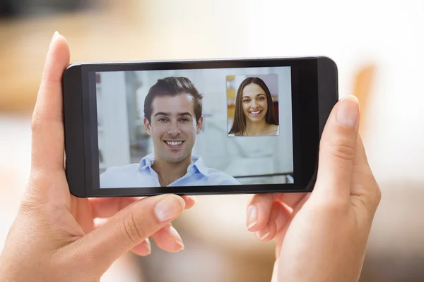Primo piano di una mano femminile che tiene uno smartphone durante uno skype vid — Foto Stock