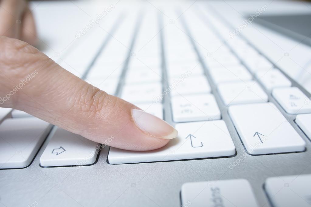 Female hand using computer keyboard, enter button