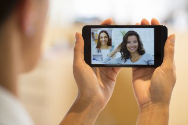 bir akıllı telefon sırasında skype vid tutan bir el closeup