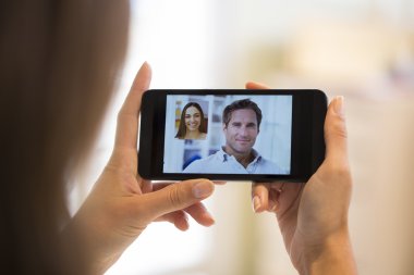 bir akıllı telefon sırasında skype vid tutan bir el closeup