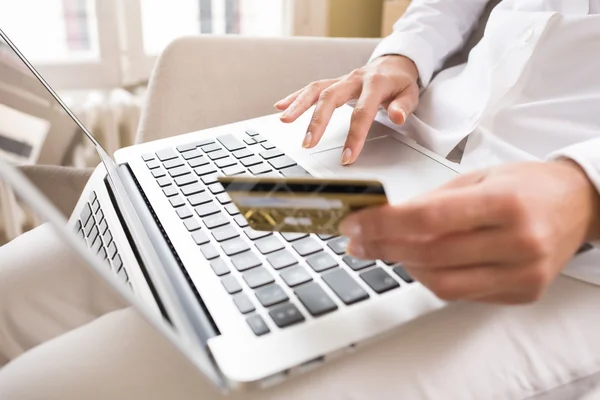 Primeros planos de las manos de una mujer sosteniendo una tarjeta de crédito y utilizando el ordenador — Foto de Stock