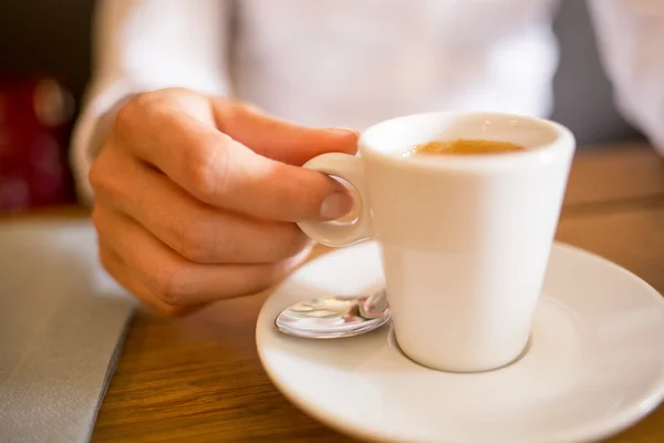 Woman drinking espresso in cafe