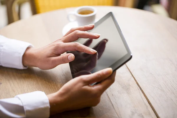 Primo piano di mani donna utilizzando il suo tablet pc nel ristorante — Foto Stock