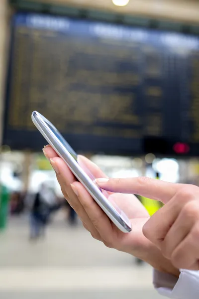 Close up of hands woman using her cell phone in train station, b — Stock Photo, Image
