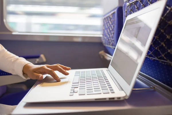 Close-up woman hands typing on a laptop keyboard in the train — Stock Photo, Image