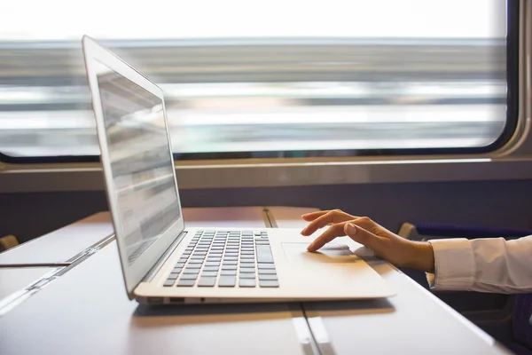 Close-up woman hands typing on a laptop keyboard in the train — Stock Photo, Image