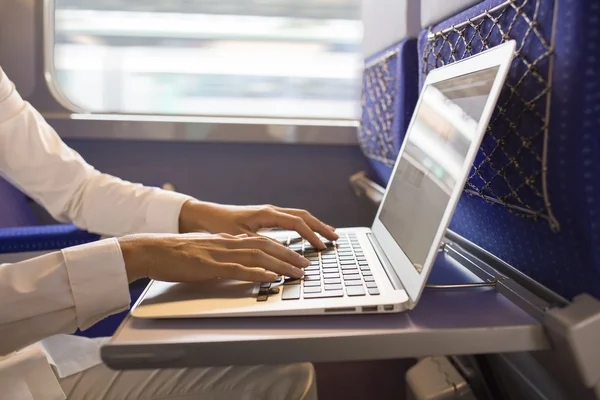 Close-up woman hands typing on a laptop keyboard in the train — Stock Photo, Image