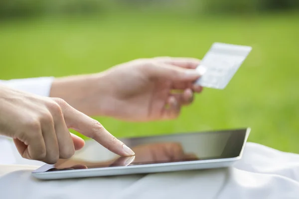 Närbild kvinnas händer håller ett kreditkort och använder tablet pc — Stockfoto