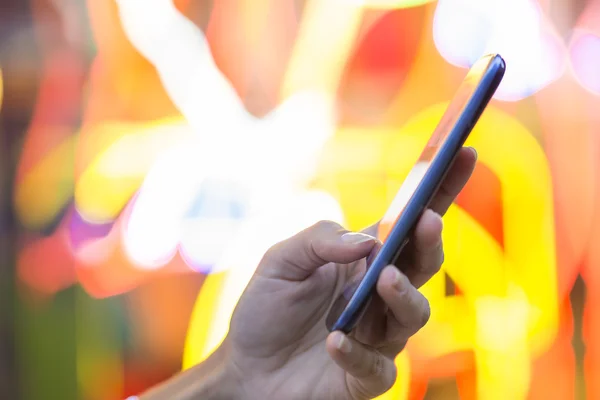 Téléphone portable dans la main d'une femme, fond graphique en couleurs — Photo