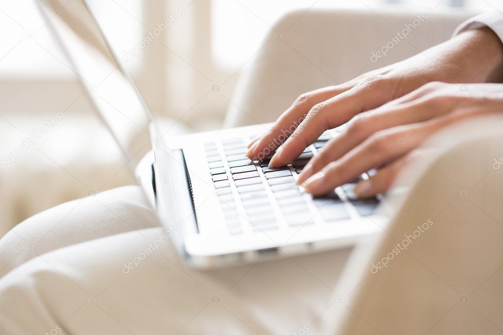 Female hands typing on a laptop keyboard
