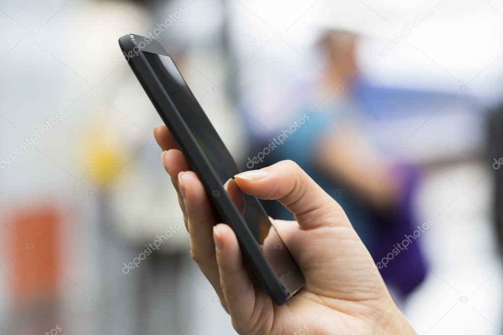 Close up of hands woman using her cell phone at a train station
