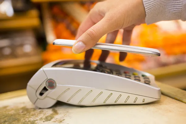 Mulher pagando com tecnologia nfc no telefone móvel, compras, supe — Fotografia de Stock