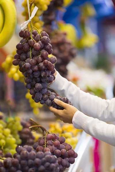 Mulher compra frutas e legumes em um mercado — Fotografia de Stock