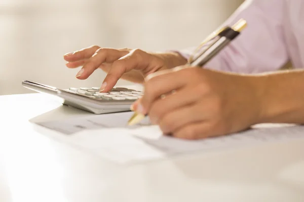 Mains de femme avec une calculatrice et un stylo, Comptabilité . — Photo