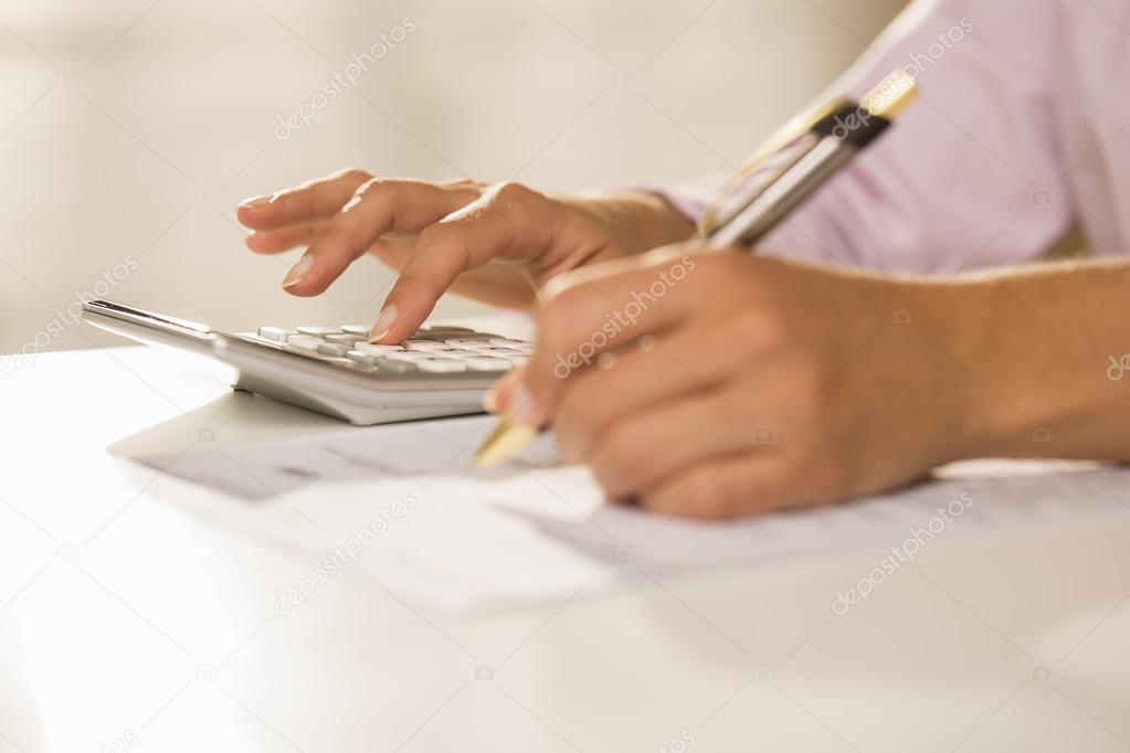 Woman's hands with a calculator and pen, Accounting.