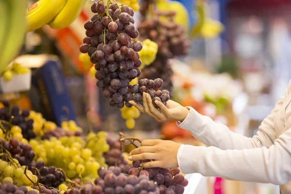Mulher compra frutas e legumes em um mercado — Fotografia de Stock