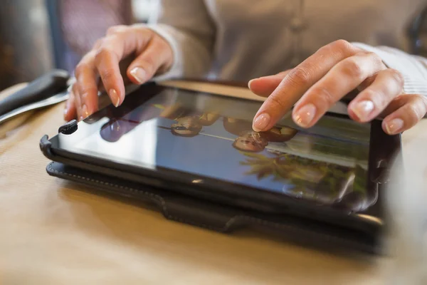 Femme utilisant une tablette numérique dans un café, des photos de vacances — Photo