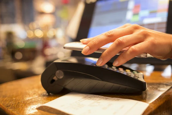 Mujer pagando con tecnología NFC en el teléfono móvil, restaurante, ca —  Fotos de Stock