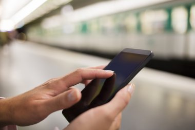 metro platformda cep telefonu kullanan kadın