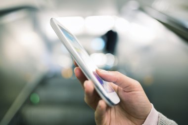 Metroda yürüyen merdiven içinde cep telefonu kullanan kadın