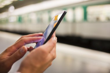 Metroda akıllı telefon kullanan kadın