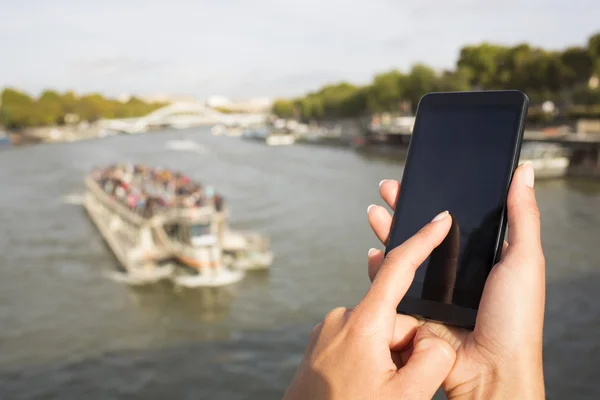 Kobieta za pomocą jej telefon komórkowy tło Paryż — Zdjęcie stockowe