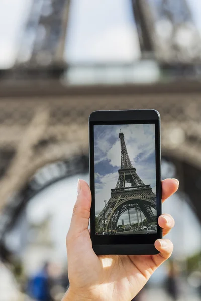 Woman in Paris taking pictures of the Eiffel Tower with her cell phone — Stock Photo, Image