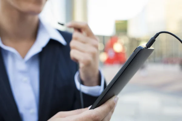 Zakenvrouw met behulp van haar slimme telefoon in werkomgeving — Stockfoto