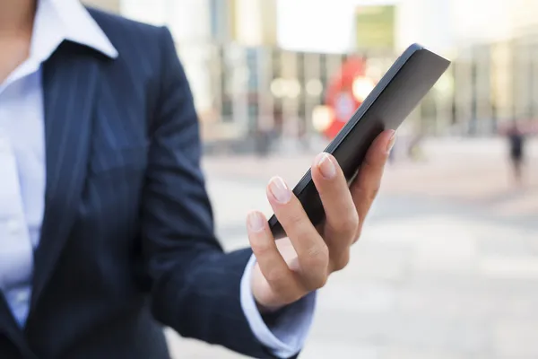 Geschäftsfrau benutzt ihr Smartphone im Arbeitsumfeld — Stockfoto
