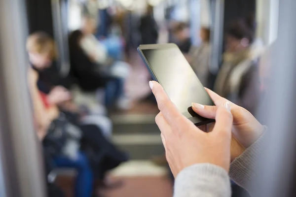 Mujer usando su teléfono celular en el metro Imagen de archivo