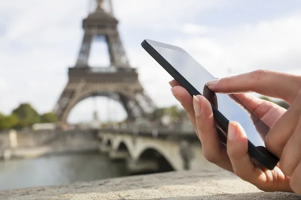 에펠 탑 앞에서 그녀의 스마트 휴대 전화를 사용 하 여 여자 — 스톡 사진