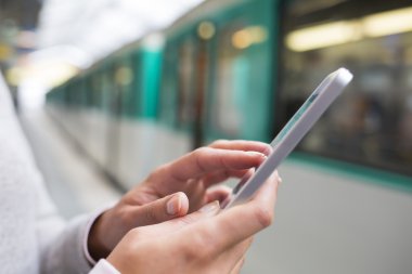 Metroda akıllı telefon kullanan kadın