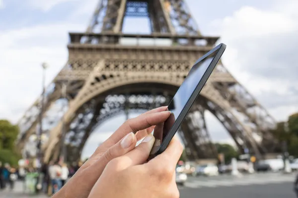 Mulher usando seu telefone inteligente na frente da Torre Eiffel — Fotografia de Stock
