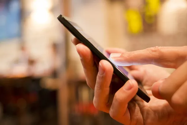 Mann benutzt Mobiltelefon in Restaurant, Café, Bar — Stockfoto