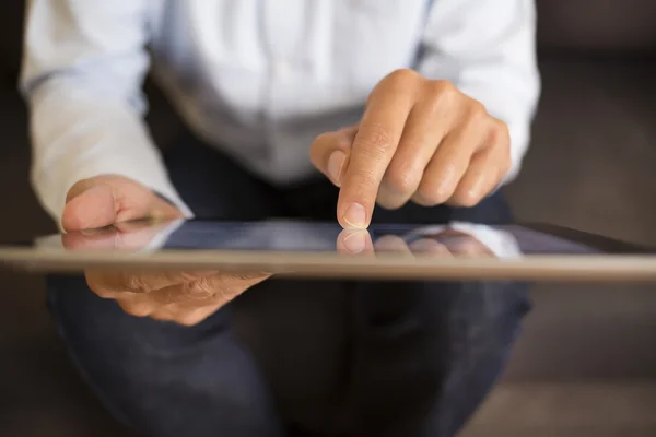 Muž pomocí počítače tablet pc na pohovce, vnitřní — Stock fotografie