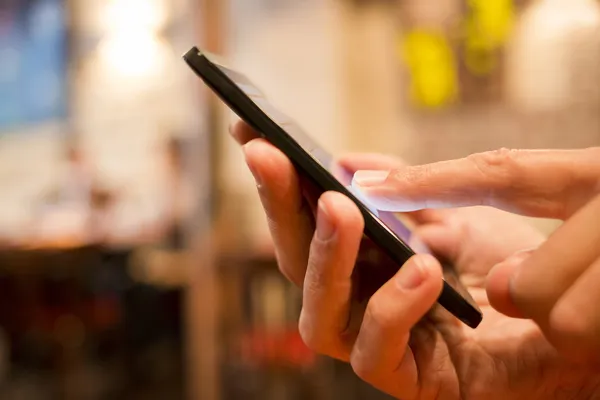 Hombre usando un teléfono móvil en restaurante, cafetería, bar Imágenes de stock libres de derechos