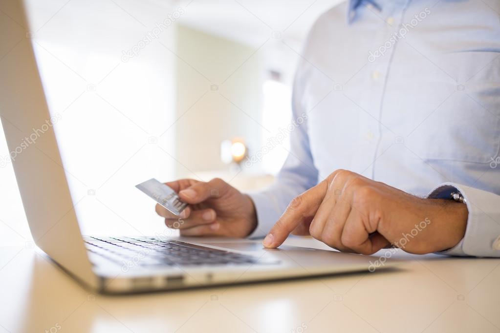 Man using credit card and laptop, shopping on line.indoor