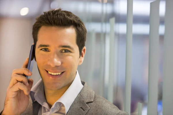 Businessman in hall and talking on phone — Stock Photo, Image