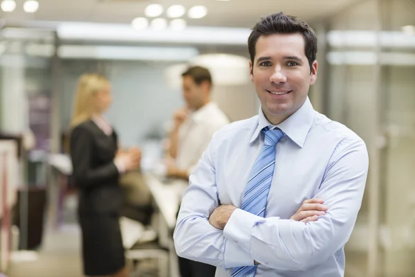 Hombre de negocios sonriente en el pasillo de oficinas — Foto de Stock