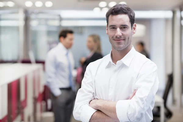 Hombre de negocios sonriente en el pasillo de oficinas — Foto de Stock