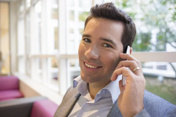 Businessman using cellphone on sofa — Stock Photo, Image