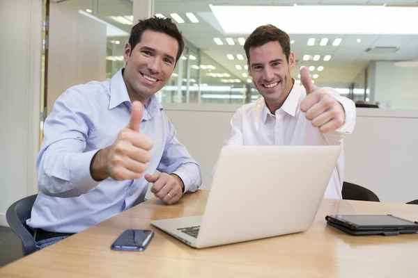 Empresários trabalhando juntos e mostrando polegares — Fotografia de Stock