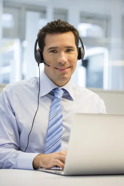 Üzletember dolgozik laptop headset — Stock Fotó
