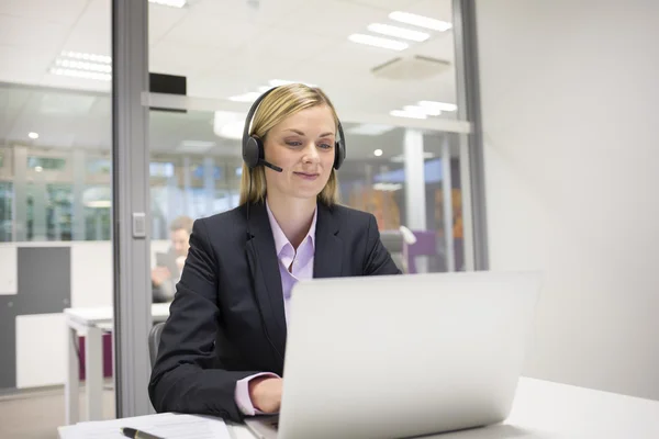 Mujer de negocios en la oficina con auriculares — Foto de Stock