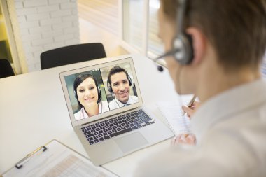 Businessman on videoconference with headset clipart