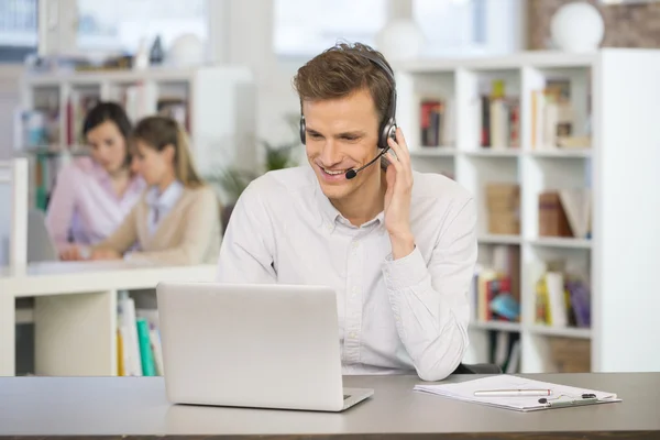 Businessman in office with headset — Stock Photo, Image