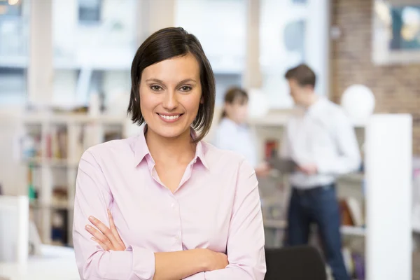 Affärskvinna med korsade armar i office — Stockfoto