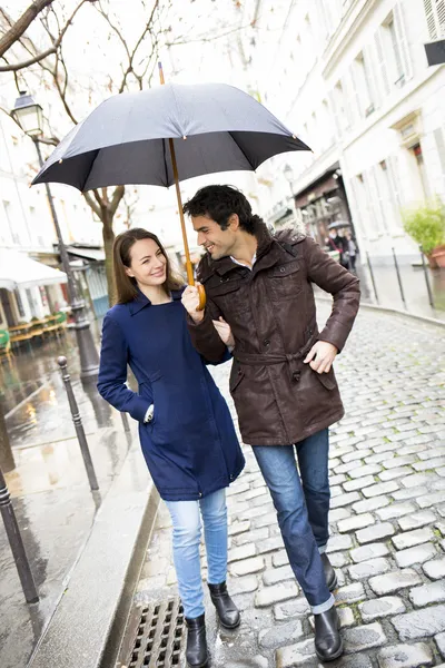 Couple with umbrella walking under rain