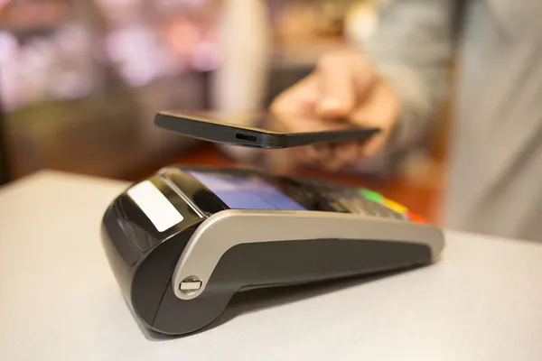 Mulher pagando com tecnologia NFC no celular, no supermercado — Fotografia de Stock